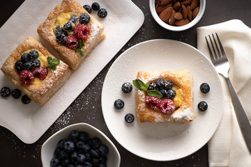 White Plates with Puff Pastries, Berries and Almonds Dessert