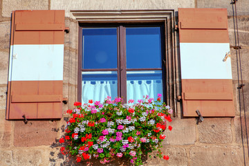 Fototapeta na wymiar window shutters in retro style with flower beds 