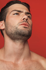 Obraz premium Muscle strong beautiful stripped male model in white casual suit on red isolated font background 