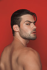 Obraz premium Muscle strong beautiful stripped male model in white casual suit on red isolated font background 