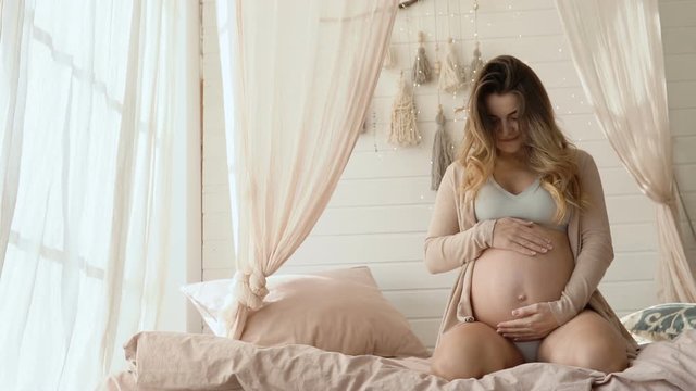 Pregnant lady lovingly stroking and caressing her beloved tummy, expectance
