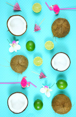 Fototapeta na wymiar Coconut summertime theme flat lay creative layout overhead with drinking, straws, coconuts and limes on modern blue background.