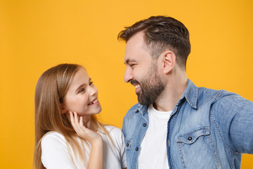 Obraz premium Close up of bearded man with child baby girl. Father little kid daughter isolated on yellow background. Love family day parenthood childhood. Doing selfie shot on mobile phone, looking at each other.