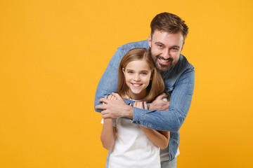 Fototapeta premium Cheerful bearded man in casual clothes have fun with cute child baby girl. Father little kid daughter isolated on yellow background in studio. Love family day parenthood childhood concept. Hugging.