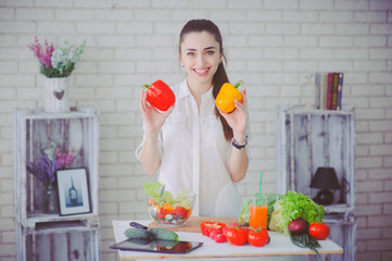 Pretty girl preparing fresh vegetable salad in her kitchen