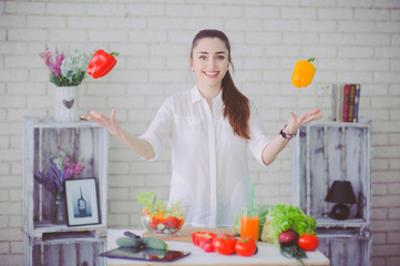 Pretty girl preparing fresh vegetable salad in her kitchen