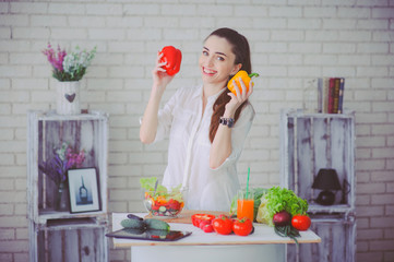 Pretty girl preparing fresh vegetable salad in her kitchen