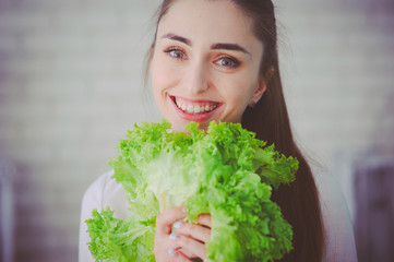 Pretty girl preparing fresh vegetable salad in her kitchen