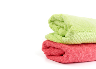 stack of colored cotton terry folded towels on a white background