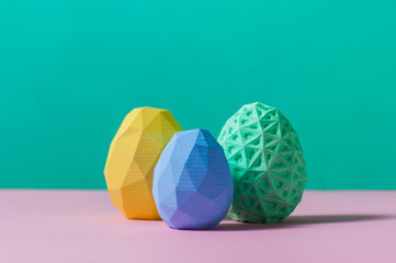 Color geometric Easter eggs on turquoise and pink background
