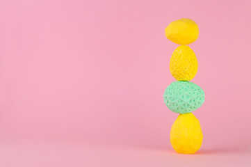 Easter eggs standing on pink background with copy space