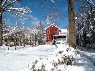 red suburban house in winter wonderland the day after the snow storm