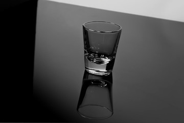 Tequila glasses and their reflections in black and white background 