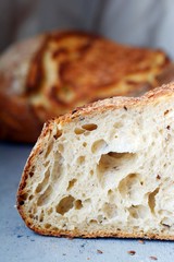 Homemade Freshly Baked Country Bread  made from wheat and whole grain flour on a gray-blue background. French Freshly baked bread. Slicing homemade bread 