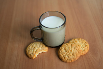 Сup with milk and cookies with orange zest on wooden background. Cookies and milk - a sweet dessert