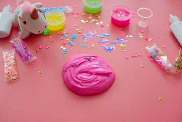 a girl making slime herself. child making slime on pink background.