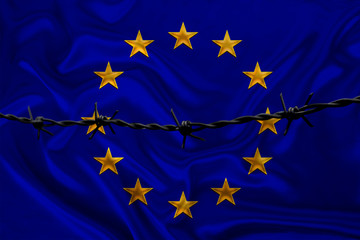 iron barbed wire against the background of the national silk flag of europe, concept of imprisonment for offenders, for the siege area