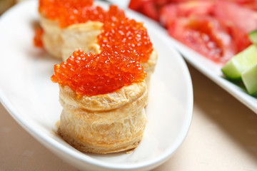 Red caviar on tartlets on a white plate