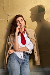 Beautiful young redhead woman wearing teddy jacket and white shirt and red neckpiece is thinking of...