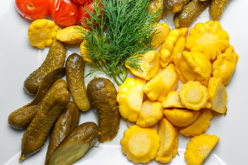 Pickles, tomatoes, squash and dill on a white background