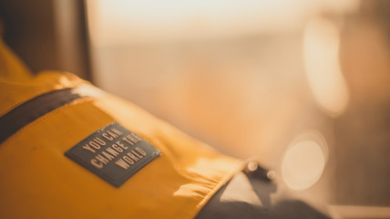 Tourist hiking backpack with "You can change the world" words and equipment during a trekking adventure - freedom, travel, active lifestyle concept.