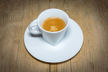 close up white cup of espresso on vintage wooden table