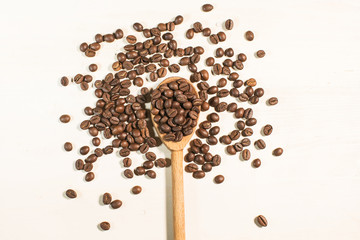 coffee beams and wooden spoon isolated on white
