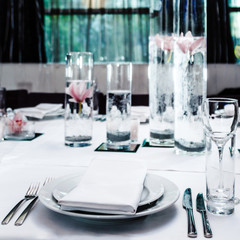 Serving tables in a restaurant with peonies and orchids