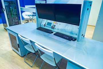 Monitors are hanging over the desk in the control room. Item for enterprise management. Point control room at the factory. The place of the dispatcher in the server room. A place to monitor security