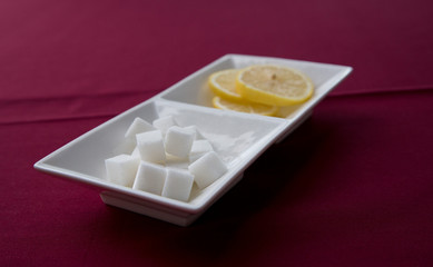 Condiment selections for tea hold sugar cubes in forefront