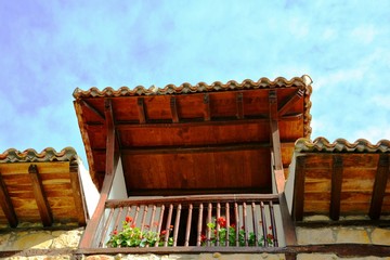 a balcony with red flowers