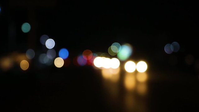 Colorful Lights of the night city with reflection background. Defocus headlights of moving cars urban traffic. Abstract bright blured colored bokeh. Slow motion