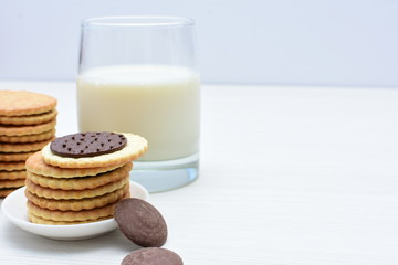 Chocolate cookies accompanied by glass of milk