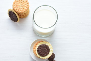 Chocolate cookies accompanied by glass of milk