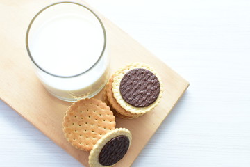 Chocolate cookies accompanied by glass of milk