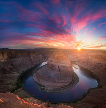 Beautiful Horseshoe Bend sunburst sunset and colorful clouds with reflections