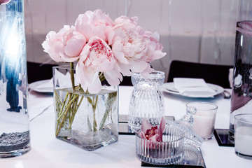 Serving tables in a restaurant with peonies and orchids