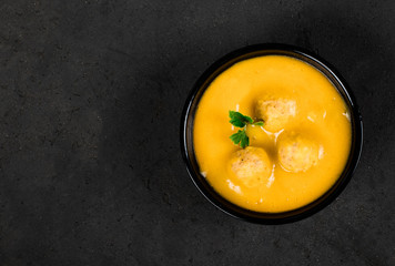 Pumpkin cream soup with meatballs on a light background