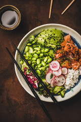 Healthy dinner. Flat-lay of salmon poke bowl or sushi bowl with various vegetables, greens, sushi...