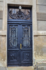 Old metal doors with stained-glass windows, forged grills and ornaments. Architectural details for background. Decorative processing of metal door.