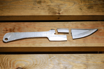 Broken throwing knife on a wooden background