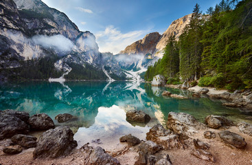 Amazing view of Lago di Braies (Braies lake, Pragser wildsee) at sunrise. Trentino Alto Adidge, Dolomites mountains, South Tyrol, Italy, Europe. Boats at the lake. Fanes-Sennes-Braies national park.