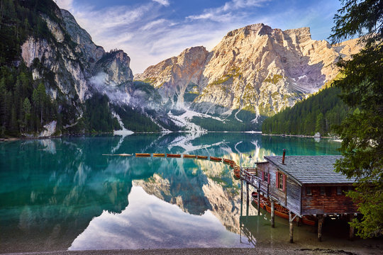 Amazing view of Lago di Braies (Braies lake, Pragser wildsee) at sunrise. Trentino Alto Adidge, Dolomites mountains, South Tyrol, Italy, Europe. Boats at the lake. Fanes-Sennes-Braies national park.