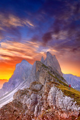 Amazing view on Seceda peak. Trentino Alto Adige, Dolomites Alps, South Tyrol, Italy, Europe. Odle mountain range, Val Gardena. Majestic Furchetta peak in morning sunlight. Man traveler traveling.