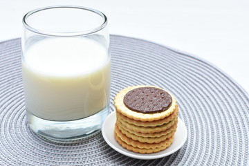 Chocolate cookies accompanied by glass of milk