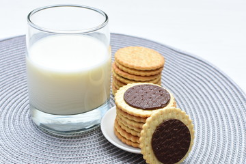 Chocolate cookies accompanied by glass of milk