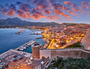 View from the walls of the citadel of Calvi on the old town with historic buildings at evening...