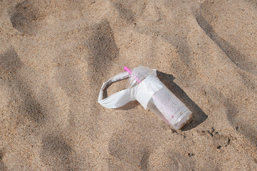 Plastic glass thrown on the Sandy beach in nature, environmental pollution, plastic polluting