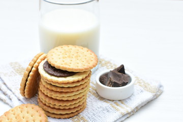 Chocolate cookies accompanied by glass of milk