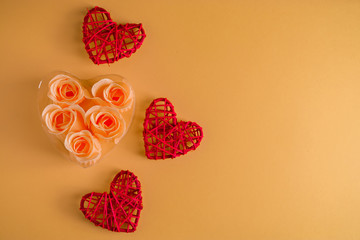 Red hearts from twigs of vines and roses on a beige background.